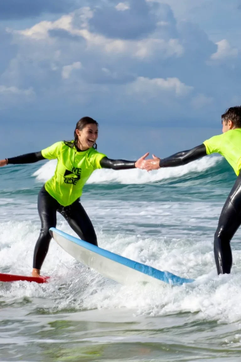 Allieva e istruttore WE RIDE durante una lezione di surf tra le onde