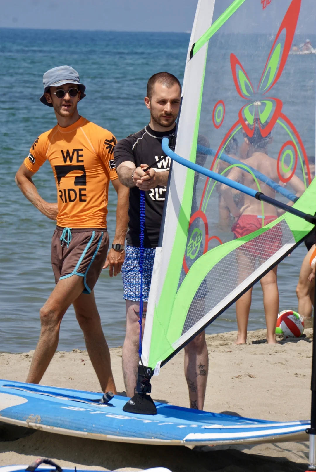 Preparazione della vela durante una lezione Windsurf WE RIDE in spiaggia